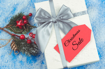 Red label on a gift box with the words Christmas Sale