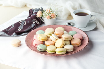 French colorful macarons dessert and cup of coffee on the table