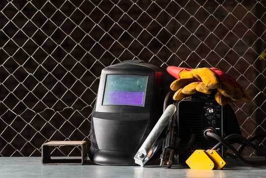 Welding equipment on the metal workbench background. Front view.
