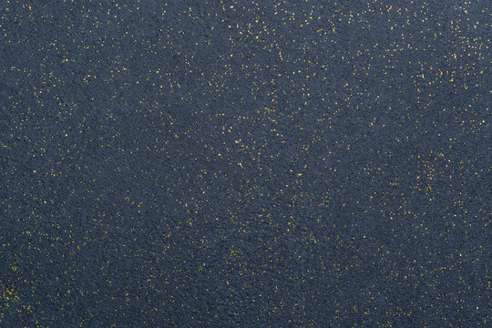 A sheet of navy blue decorative interlining with golden glitter dots. Non-woven fabric as a background. Star galaxy universe concept