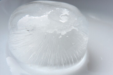 A melting ice-cube, white background