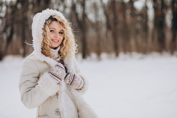 Young woman with curly hair walking in a winter park