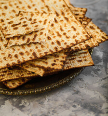 Jewish kosher bread matzah on a plate. Gray marble background. Minimalism. There are no people in the photo. Close-up. Jewish Passover, history, religion, Judaism, traditions, rituals.
