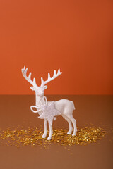 Christmas toy deer on brown background. Modern Christmas still life concept 
