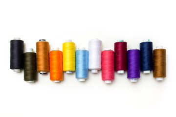 colorful spools of thread on a white background, flat lay