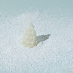 Christmas tree with sparkle in snow on ice blue background. Winter holidays and New Year layout.