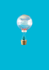 Christmas bauble flying with green Christmas tree with snow in the basket against sky blue background. Creative winter holidays and New Year concept.