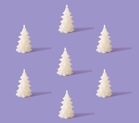 Christmas creative pattern made of white shiny candles with flame in shape of Christmas tree. Pastel purple background. Winter holidays and New Year idea.