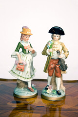 Art ceramics. A guy and a girl with fashionable clothes from the 1800s. Horizontal.
