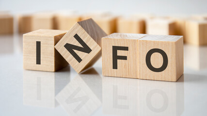 four wooden blocks with the letters info on the bright surface of a gray table, business concept - obrazy, fototapety, plakaty