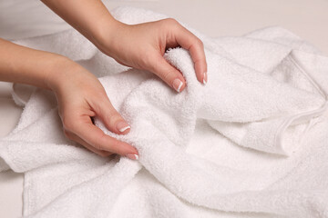 Woman touching soft white towel, closeup view