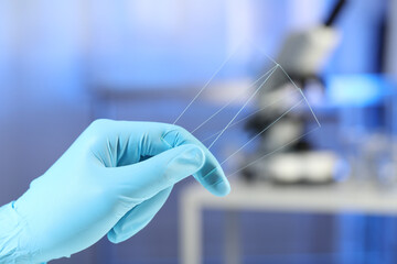 Scientist holding clean glass microscope slides in laboratory, closeup