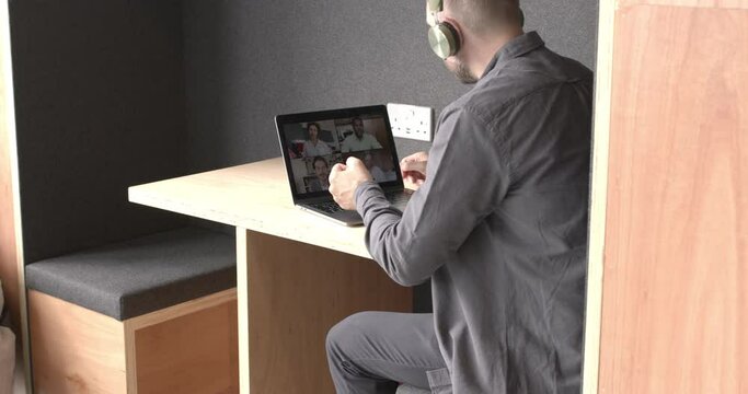 Business man on video call working in coworking office booth