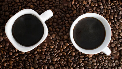 Fototapeta premium two cups of black coffee top view. a cup of coffee on a background of brown beans