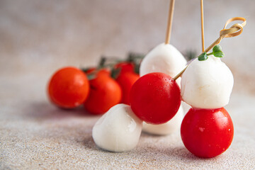 canapes mozzarella and tomato caprese salad on a skewer meal snack on the table copy space food background rustic. top view keto or paleo diet veggie vegan or vegetarian food