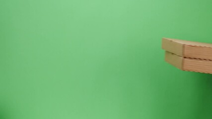 Square cardboard boxes on green background. Preparing take away meals. Online contactless food shopping. Food delivery service. Courier in protective gloves giving order, delivering to customer. 