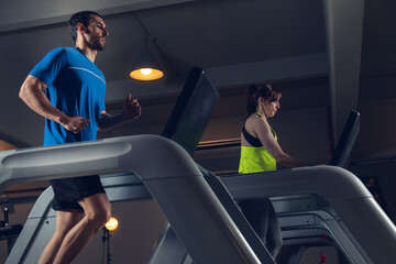 young couple running on running machine at gym fat Burning Cardio Workout