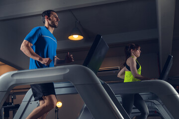 young couple running on running machine at gym fat Burning Cardio Workout