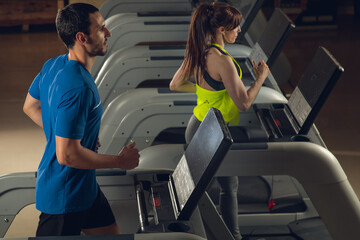 young couple running on running machine at gym fat Burning Cardio Workout