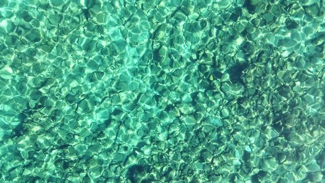 Top view of transparent shallow turquoise ocean sea water surface and rock. Aerial top view, Aquamarine background