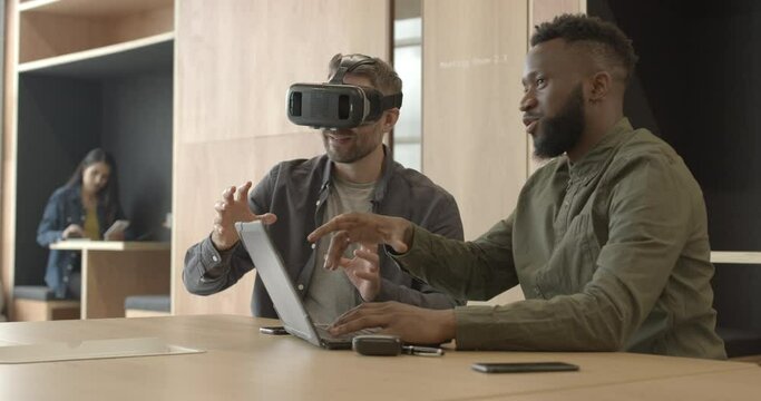 Engineers working with virtual reality headset in creative office