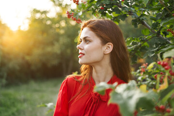 Naklejka premium Woman red dress green leaves nature summer