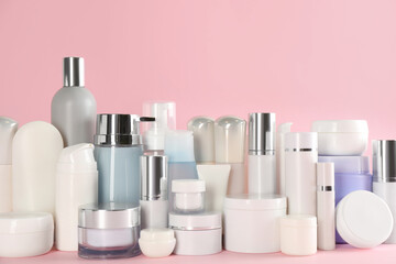 Many different cosmetic products on pink background