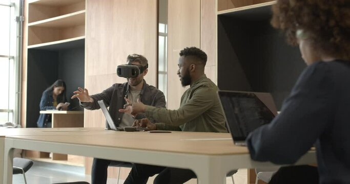 Engineers working with virtual reality headset in creative office