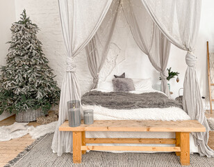 Christmas decorated rustic wooden bedroom interior in gray, white, silver colours with big baldaquin bed, fake fur blanket, candles, Christmas fir tree and gifts on floor. Christmas morning  © somegirl