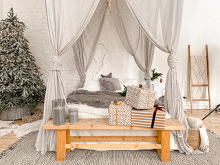 Christmas decorated rustic wooden bedroom interior in gray, white, silver colours with big baldaquin bed, fake fur blanket, candles, Christmas fir tree and gifts on floor. Christmas morning  © somegirl