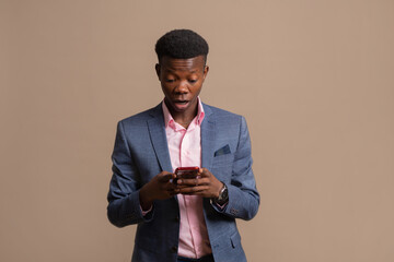 scared african male in a jacket with a mobile phone