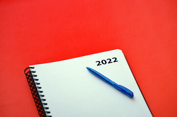on the table is a notebook and a pen for records for 2022