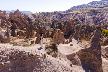 Woman looking on landscape of spectacular volcanic rock formations in Cappadocia, Turkey
