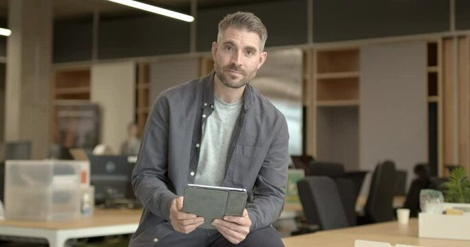 Portrait of Business man working in office on digital tablet sitting on desk