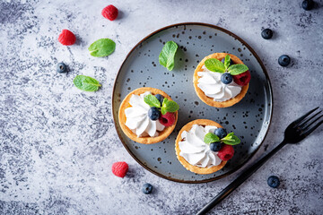 Sweet tartlets with cream and berries
