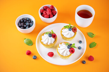 Obraz na płótnie Canvas Sweet tartlets with cream and berries