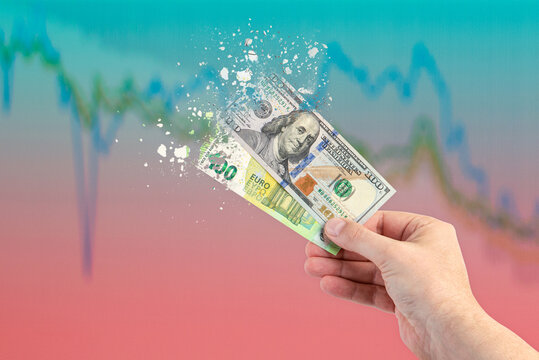 Inflation, hyperinflation, stagflation. One hundred dollar and one hundred euro banknotes splatter on the falling red graph. The concept of inflation and crisis in Europe and the United States.