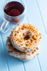 Sweet glazed donut with sprinkles and tea