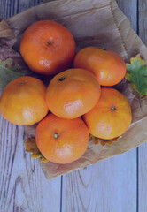 Zenith view, group of tangerines on kraft paper bag and old boards. Copy space.