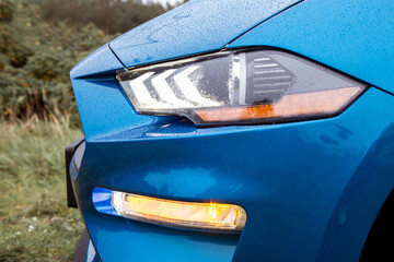 View of the front headlight of a blue sports car