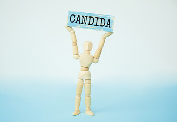 Candida - word from wooden blocks with letters, a parasitic fungus candida concept, blue background