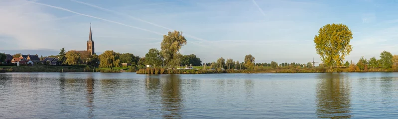 Fotobehang Panorama of Meuse river in The Netherlands with a view on traditional dutch windmill and the church of Batenburg in the autumn © Milos