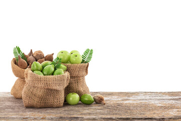Terminalia bellirica , terminalia chebula and phyllanthus emblica fruits in sack on the wooden table with clipping path.