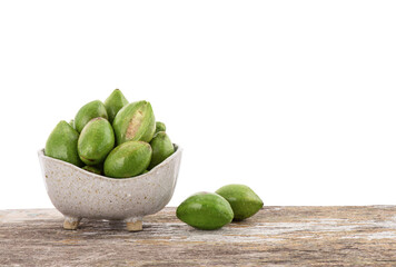 Terminalia chebula or chebulic myrobalans fruits in bowl on the wooden table with clipping path.