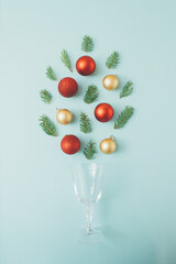 Christmas New Year and Christmas decoration concept. Minimal flat lay composition with natural fir branches and red and golden baubles. Festive blue background, season celebration idea.