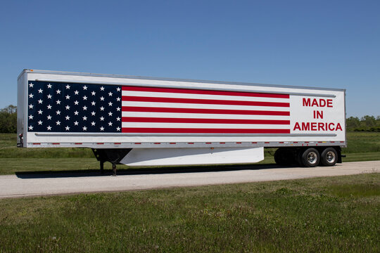 Big rig truck with the motto Made In America painted on the side with stars and stripes of the American flag.