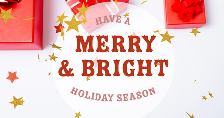 Image of merry and bright text over stars falling and presents at christmas