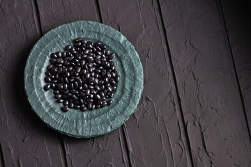 Raw black beans in the wooden bowl - Healthy food