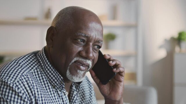 Mobile talk. Senior african american man talking on cellphone, enjoying worldwide communication at home, empty space