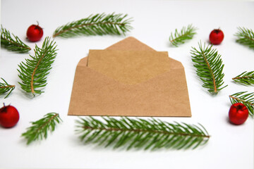 Fototapeta na wymiar Beige craft envelope, letter to Santa. Frame of fir branch or spruce branch and red berries isolated on white background. Fir tree branches. Christmas greeting card. Template for design. Side view